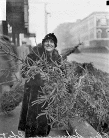 Elsie Shunemann holds branches from an evergreen tree